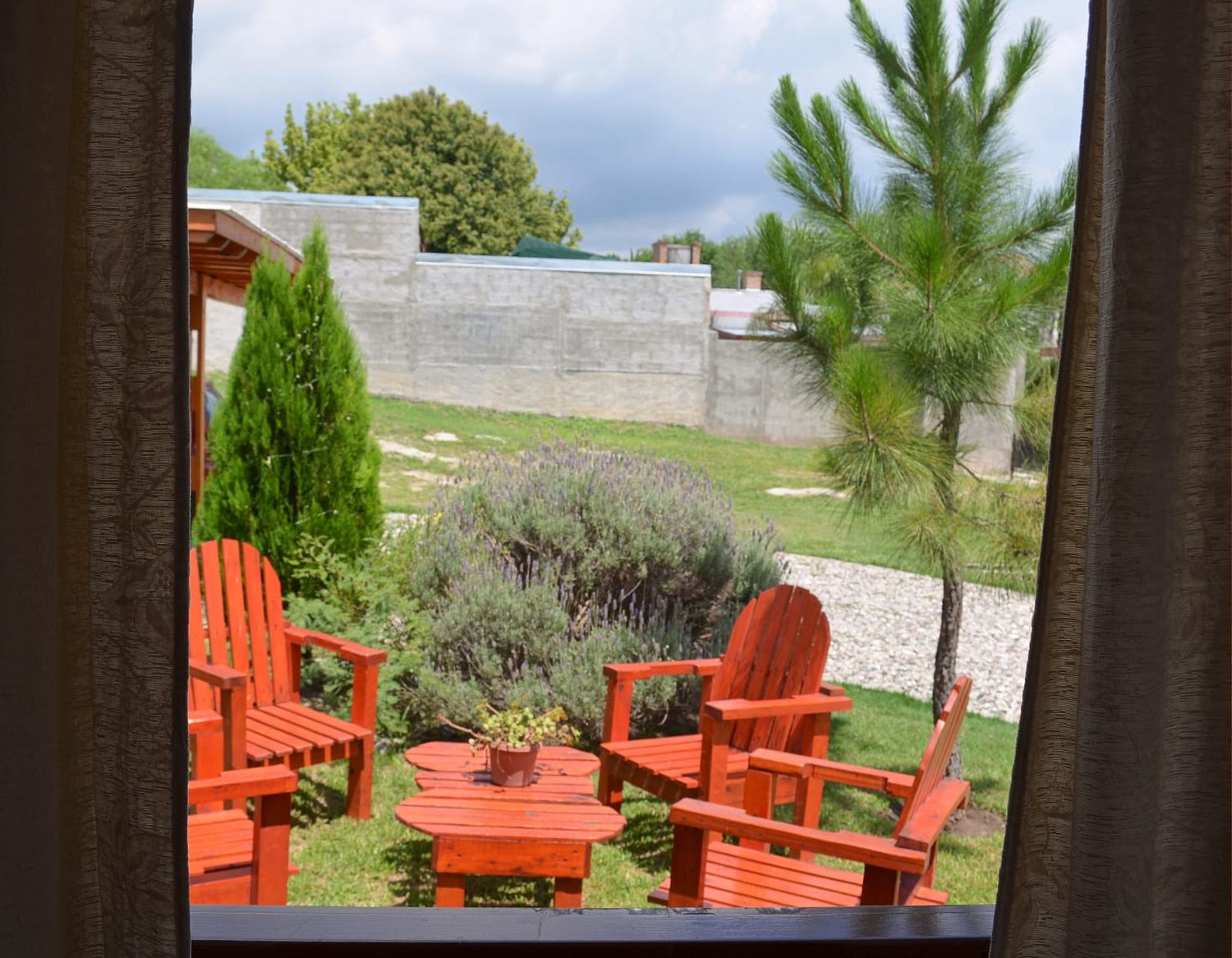 Vista desde la ventana hacia las reposeras del jardín