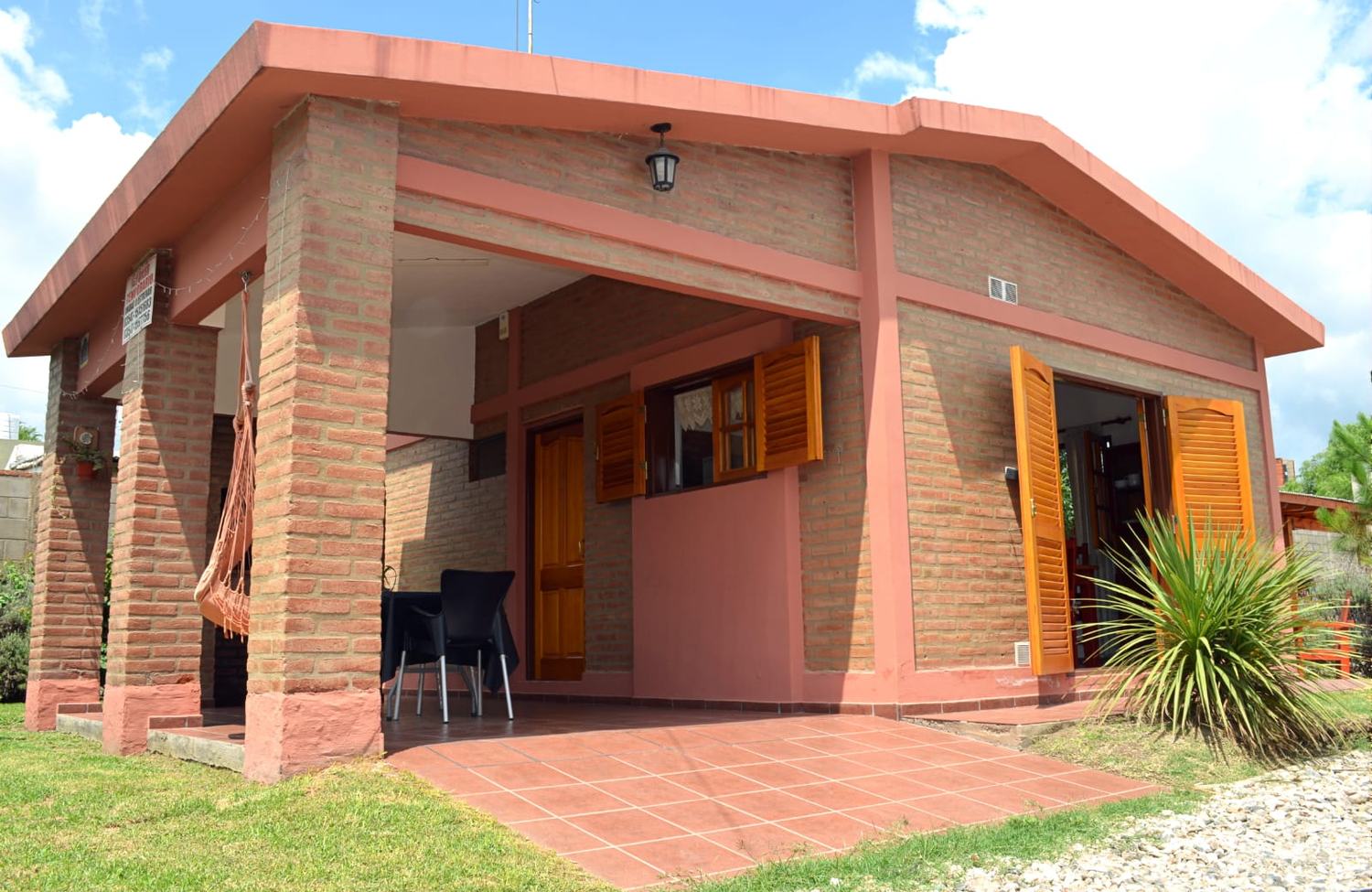 Frente de una de las casas de La Huella, con galería de ladrillo y postigos de madera